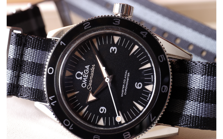 Omega Seamaster 300 wristwatch on a striped NATO strap.